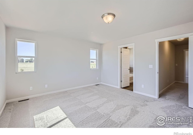 unfurnished bedroom featuring carpet and ensuite bathroom