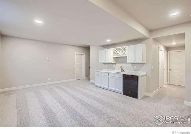 kitchen featuring light carpet, white cabinetry, dishwasher, and sink