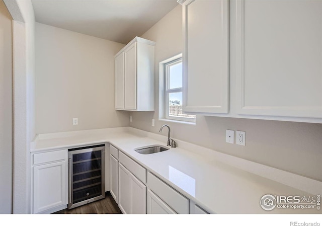 kitchen with white cabinets, sink, wine cooler, and dark wood-type flooring