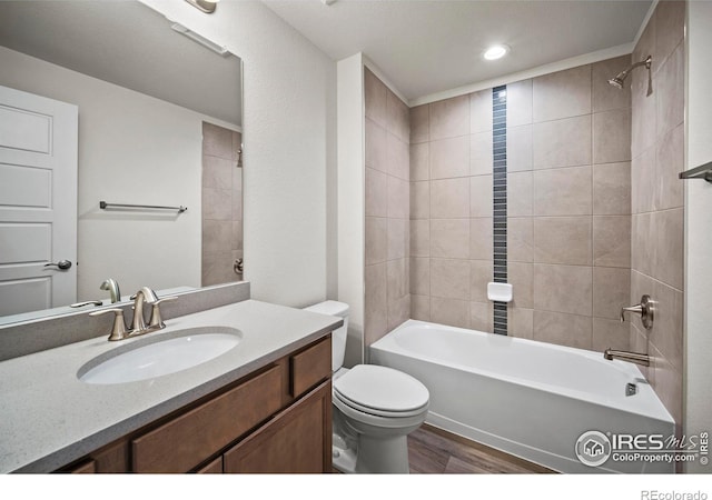 full bathroom with tiled shower / bath combo, wood-type flooring, vanity, and toilet