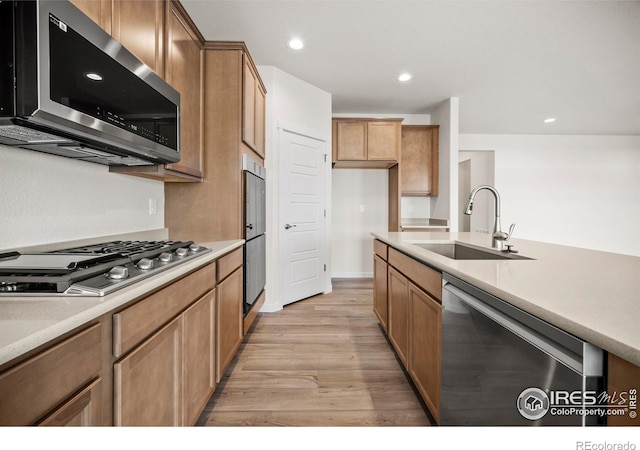 kitchen featuring stainless steel appliances, light hardwood / wood-style floors, and sink