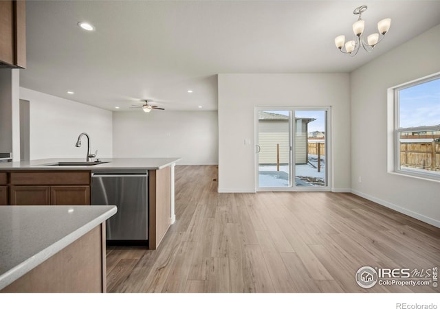 kitchen featuring ceiling fan with notable chandelier, dishwasher, sink, and light hardwood / wood-style flooring