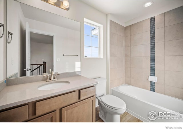 full bathroom with tiled shower / bath combo, vanity, and toilet