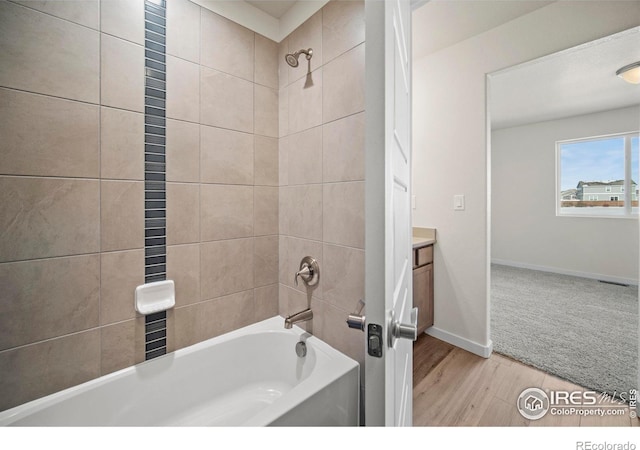 bathroom with vanity, tiled shower / bath combo, and hardwood / wood-style floors