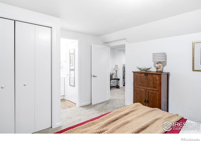 bedroom featuring light carpet, a closet, and lofted ceiling