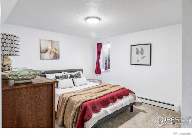 carpeted bedroom featuring a textured ceiling and a baseboard heating unit