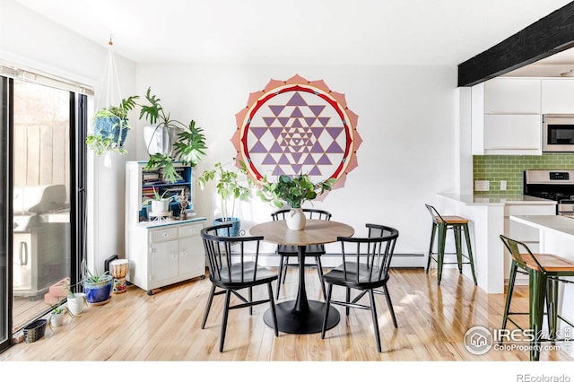 dining room with beamed ceiling and light hardwood / wood-style floors