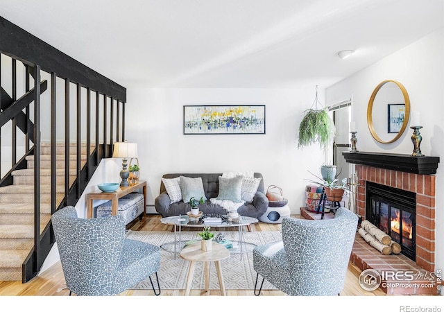 living room with baseboard heating, a fireplace, and hardwood / wood-style floors