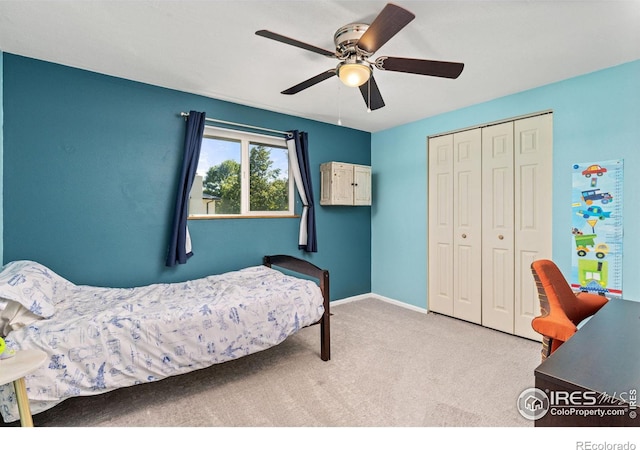 carpeted bedroom with ceiling fan and a closet