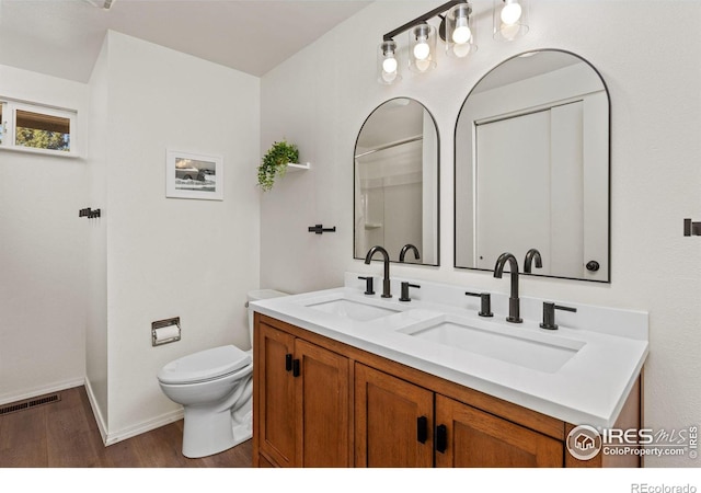 bathroom with hardwood / wood-style flooring, vanity, and toilet