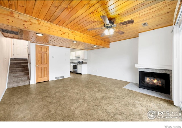 unfurnished living room featuring ceiling fan, beamed ceiling, and wood ceiling