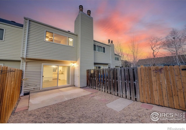 back house at dusk with a patio