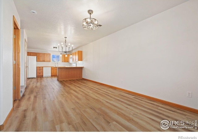 interior space with a chandelier, a textured ceiling, light hardwood / wood-style flooring, and sink