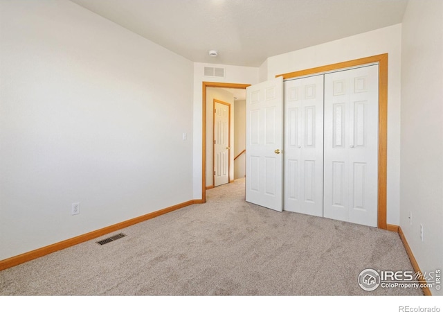 bedroom with a closet and light colored carpet