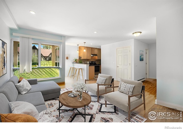 living area featuring light wood-style floors, a baseboard radiator, baseboards, and recessed lighting