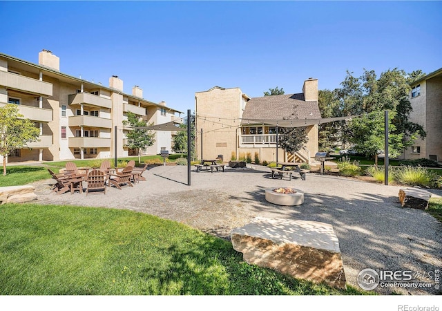 surrounding community featuring an outdoor fire pit