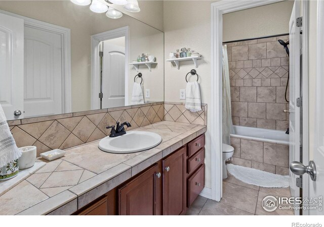 bathroom with tasteful backsplash, vanity, tile patterned flooring, and shower / bath combo