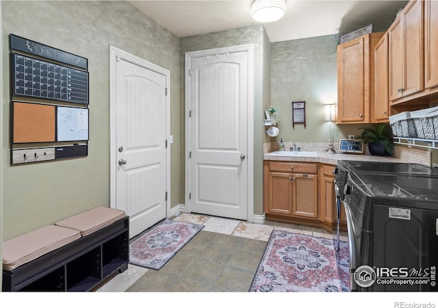 kitchen with sink, electric range oven, tile countertops, and independent washer and dryer