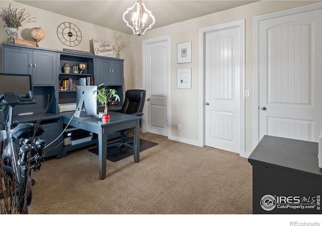 carpeted home office featuring a chandelier