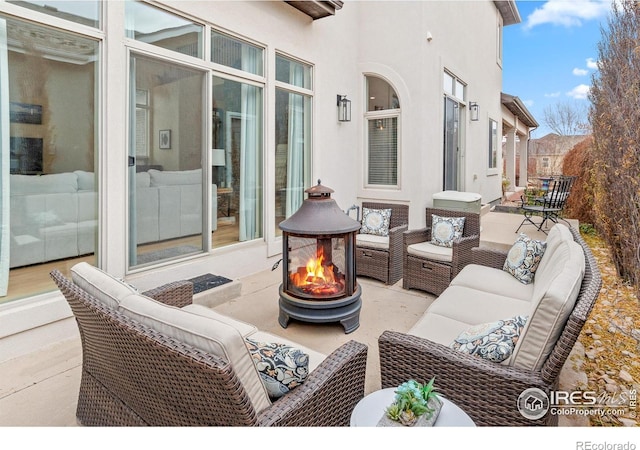 view of patio with an outdoor living space with a fire pit