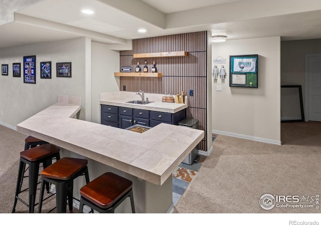 bar featuring blue cabinetry, sink, and light carpet