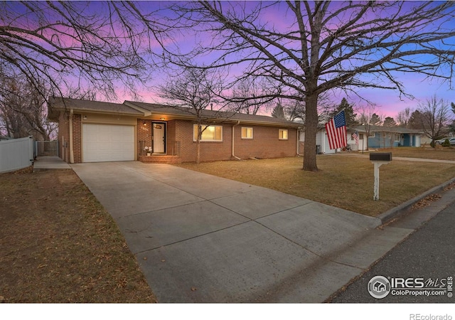 ranch-style home with a garage and a yard