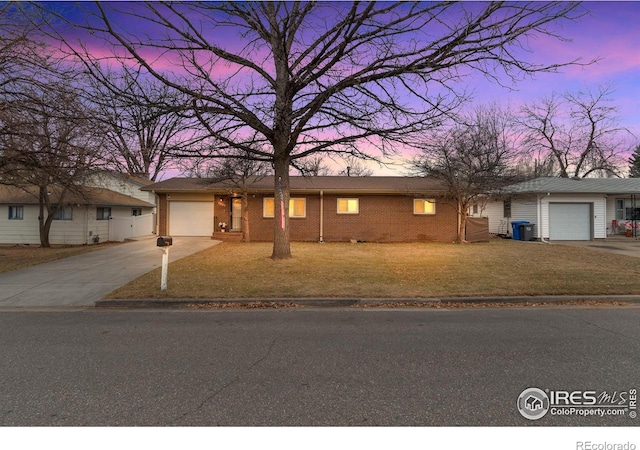 ranch-style home with a garage and a lawn