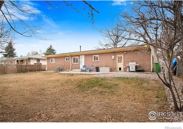 back of property featuring central AC unit, a patio area, and a lawn