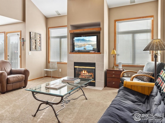 living room with carpet, a healthy amount of sunlight, and a tiled fireplace