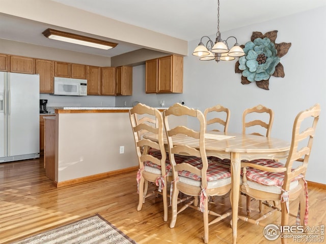 dining space featuring a notable chandelier and light hardwood / wood-style floors