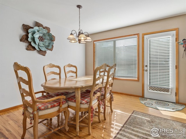 dining space with a chandelier and light hardwood / wood-style floors