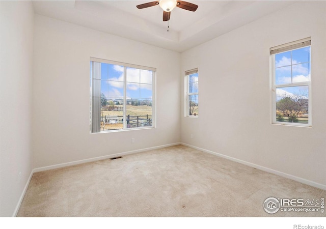 8685 Blackwood Dr, Windsor, CO 80550 - empty room featuring baseboards, a raised ceiling, carpet flooring, visible vents, and ceiling fan