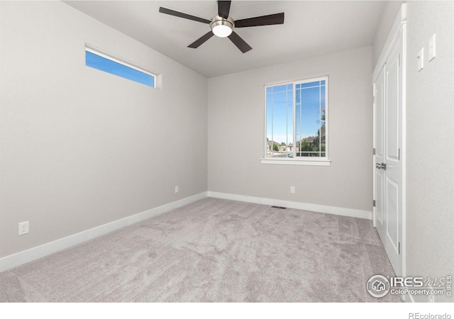 unfurnished bedroom featuring light carpet, multiple windows, and ceiling fan