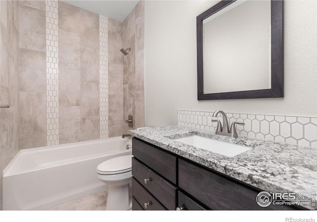 full bathroom featuring tiled shower / bath combo, vanity, tasteful backsplash, and toilet