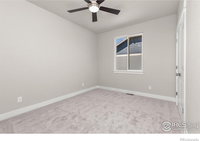 spare room with ceiling fan and light carpet