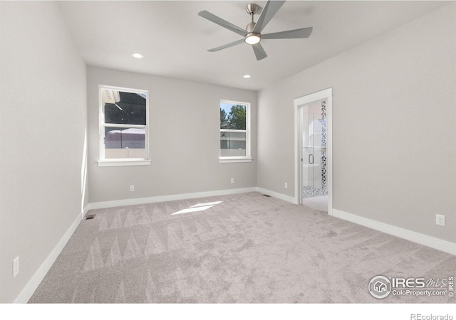 carpeted spare room featuring ceiling fan