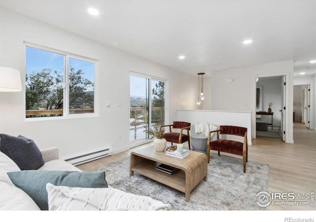 living room with a baseboard radiator and light wood-type flooring