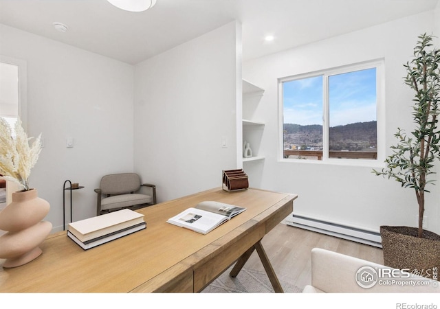 office featuring light hardwood / wood-style flooring and a baseboard heating unit