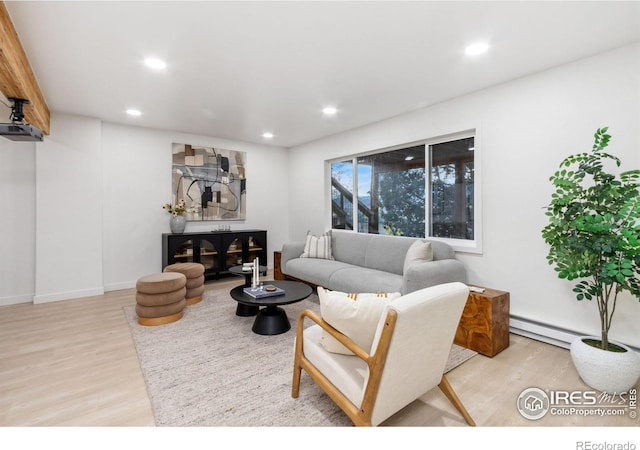 living room with light hardwood / wood-style floors and a baseboard heating unit