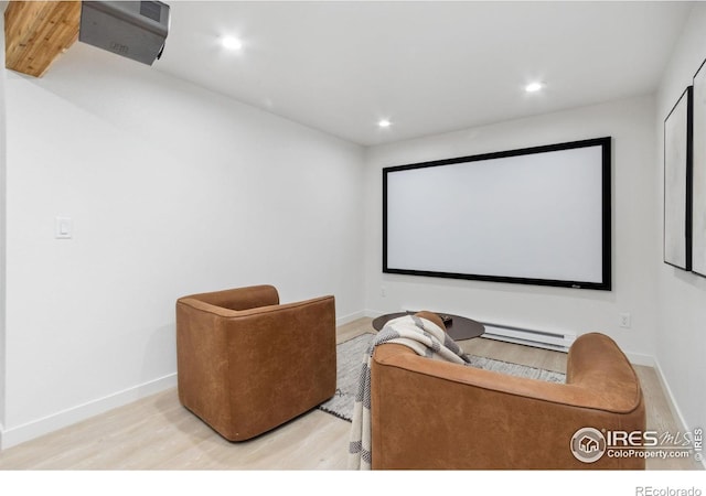 home theater room featuring a baseboard radiator and light hardwood / wood-style floors