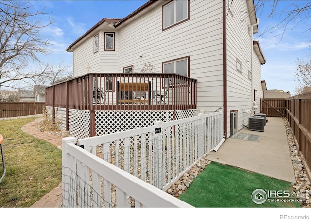 back of house with a wooden deck and cooling unit