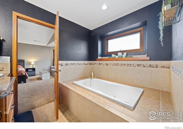 bathroom featuring tile patterned flooring and tiled tub