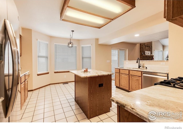 kitchen with a center island, sink, hanging light fixtures, light tile patterned floors, and stainless steel appliances