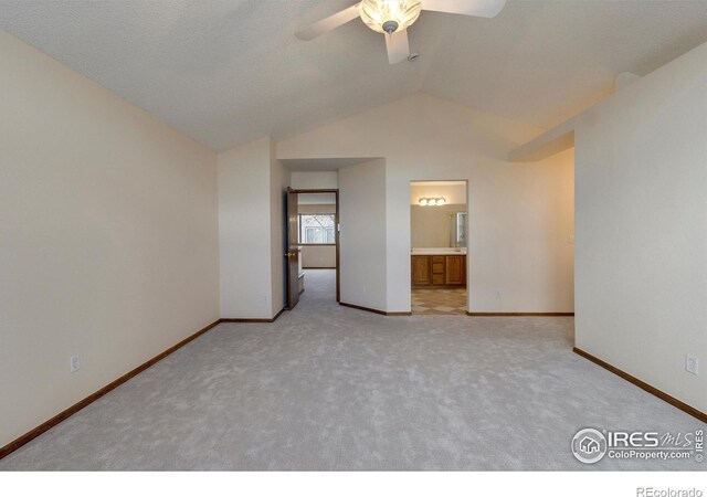 empty room with light colored carpet, ceiling fan, and lofted ceiling