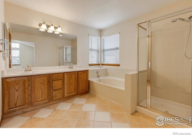 bathroom featuring tile patterned flooring, shower with separate bathtub, and vanity