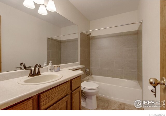 full bathroom with tile patterned flooring, tiled shower / bath combo, toilet, and vanity