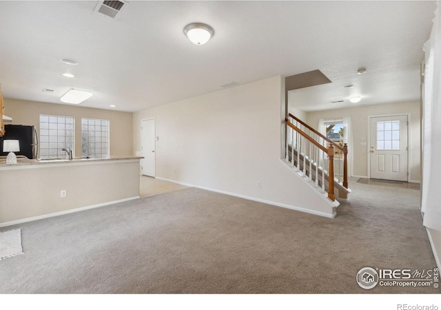 unfurnished living room featuring light colored carpet