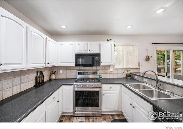 kitchen featuring backsplash, white cabinets, sink, stainless steel gas range, and dark hardwood / wood-style flooring