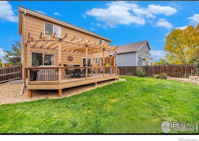 back of property with a pergola, a wooden deck, and a lawn