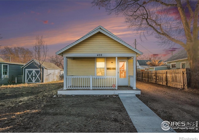 bungalow with covered porch and a shed